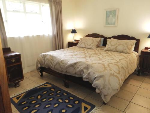 Un dormitorio con una cama grande y una ventana en Bell Park Self Catering, en Champagne Valley