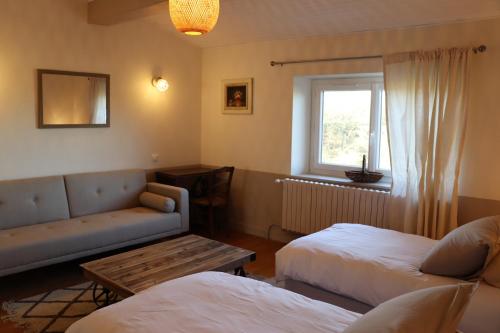 sala de estar con 2 camas y sofá en Vergers de la Bouligaire, en Mirmande