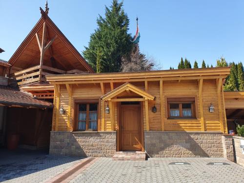 a wooden house with a front door and a driveway at Kulacs Csarda Panzio in Eger