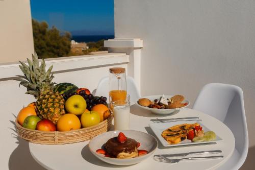 a table with plates of fruit and a basket of food at The Z Private Villa, Santorini in Monolithos