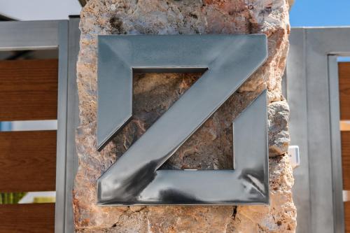a metal letter z on a stone wall at The Z Private Villa, Santorini in Monolithos