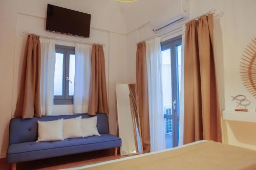 a blue couch in a room with windows and a tv at The Z Private Villa, Santorini in Monolithos