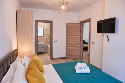 a bedroom with a bed with two towels at Glamour Sea view Family Apartments - Spa n Pools Resort in Mamaia