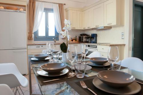 a kitchen with a table with plates and wine glasses at The Z Private Villa, Santorini in Monolithos
