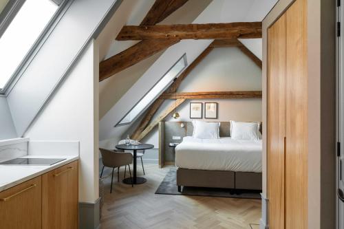a bedroom in a loft with a bed and a table at Aparthotel Hattem in Hattem