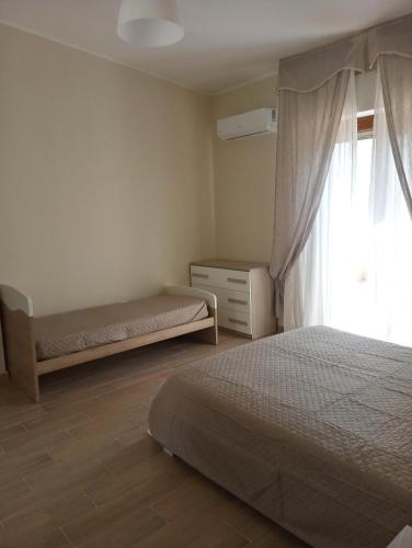 a bedroom with two beds and a window at Luminoso Appartamento con Terrazza......C.U......Q2483 in Sìnnai