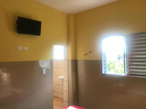 um quarto com uma televisão na parede e uma janela em Hotel Gasometro em São Paulo