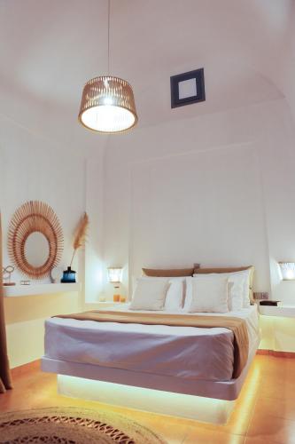 a bedroom with a large bed and a light fixture at The Z Private Villa, Santorini in Monolithos
