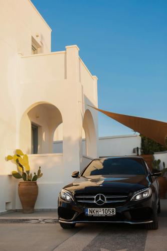 a black car parked in front of a building at The Z Private Villa, Santorini in Monolithos