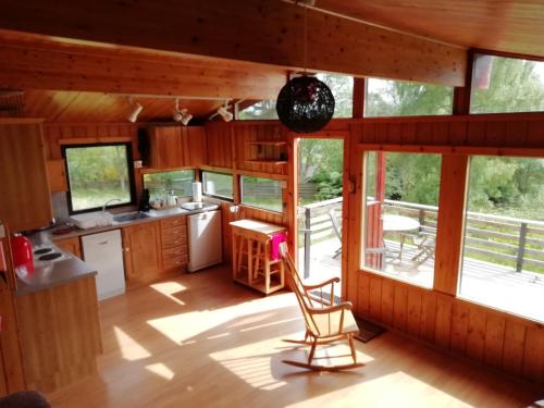 eine Küche mit einem Tisch und einem Stuhl in einer Hütte in der Unterkunft Highland Lodge in Kilmorack