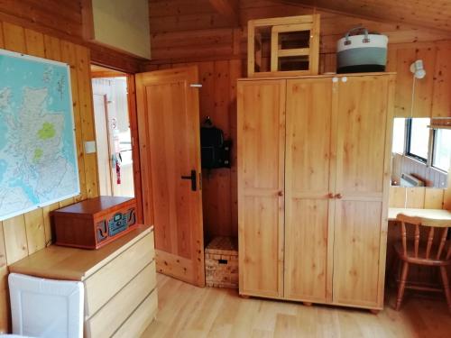 a room with wooden walls and a desk and a cabinet at Highland Lodge in Kilmorack