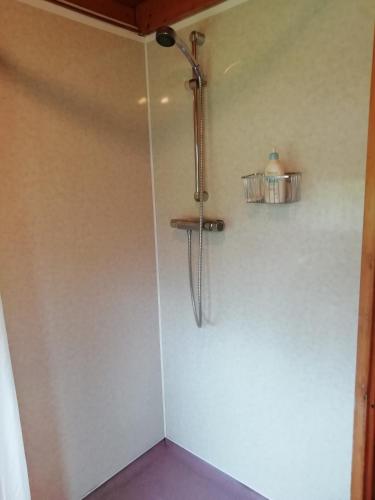 a shower in a room with a wall at Highland Lodge in Kilmorack