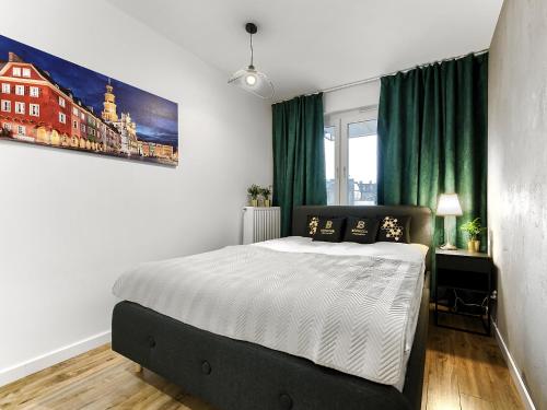 a bedroom with a bed and a painting on the wall at Apartament Bóżnicza in Poznań