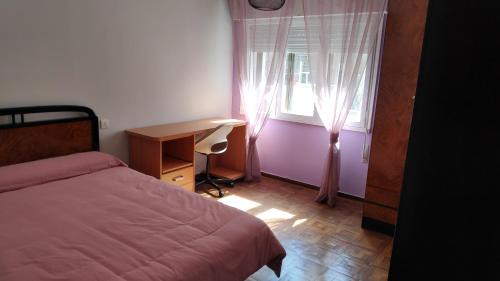 een slaapkamer met een bed, een bureau en een raam bij Centro de Gijón a seis minutos de la playa in Gijón