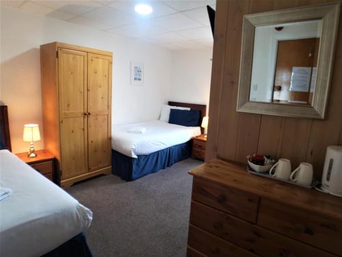 a hotel room with two beds and a mirror at The Hopton Hotel in Blackpool