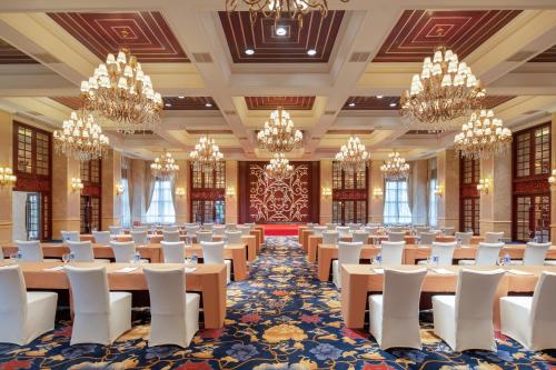 une grande salle de banquet avec des tables et des chaises dans une salle ornée de lustres dans l'établissement Holiday Inn Fuzhou New Port, an IHG Hotel, à Fuzhou