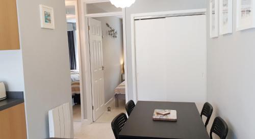 a dining room with a black table and chairs at Heated Swimming Pool Looe Polperro Cornwall Holiday Home in Looe