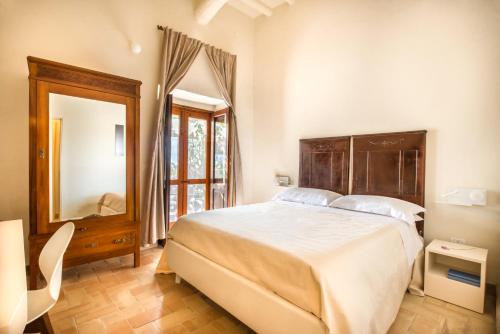 a bedroom with a large bed and a mirror at Salina Case Vacanza in Malfa
