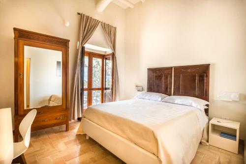 une chambre avec un grand lit et un miroir dans l'établissement Salina Case Vacanza, à Malfa
