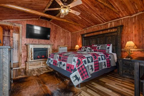a bedroom with a bed with a fireplace and a tv at Log Cabin Inn in Eureka Springs
