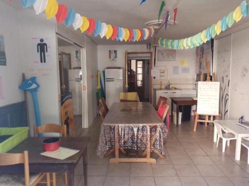 une chambre avec une table et des chaises ainsi qu'une cuisine dans l'établissement GUEST HOUSE groupe et Famille, à Saint-Paimboeuf