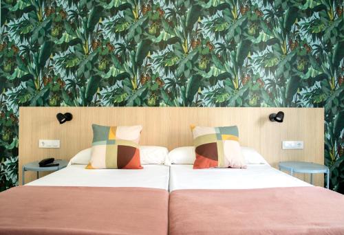 Un dormitorio con 2 camas y una pared con plantas. en 4U Miranda - Adults Only, en Santa Ponsa