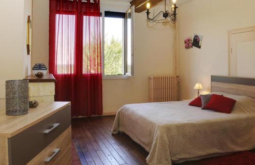 a bedroom with a bed with red curtains and a window at gite in Laubressel