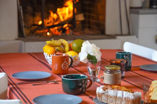 une table avec un chiffon de table, des fruits et une cheminée dans l'établissement CASTEL MT Villa spacieuse Luchon vue montagnes Pyrénées, à Luchon