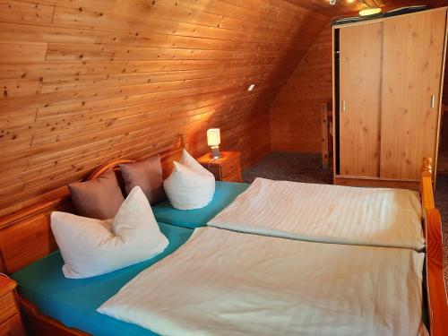 GriebenにあるMoritz - Ferienhaus östlich der Dorfstraße in Grieben Insel Hiddenseeの木製の部屋にベッド1台が備わるベッドルーム1室があります。