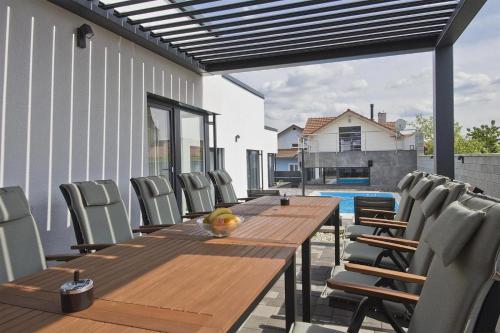 a wooden table and chairs on a patio at Apartmány Lacov Dom in Klčov