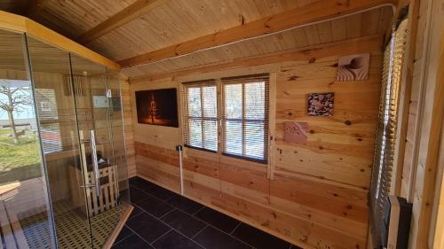 a log cabin bathroom with a shower and a window at Ferienwohnung Walfisch inkl Strandkorb in Göhren