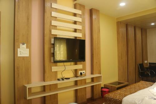 a room with a tv on a wall at Hotel Himalaya in Agartala
