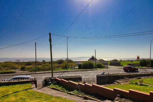 een straat met een auto die over een weg rijdt bij Blue Rose Cottage in Burry Port