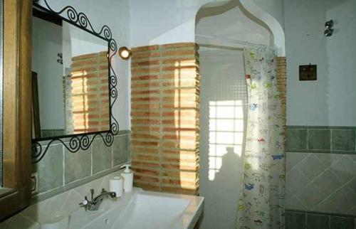a bathroom with a sink and a mirror and a shower at Casas Cueva el Mirador de Orce in Orce