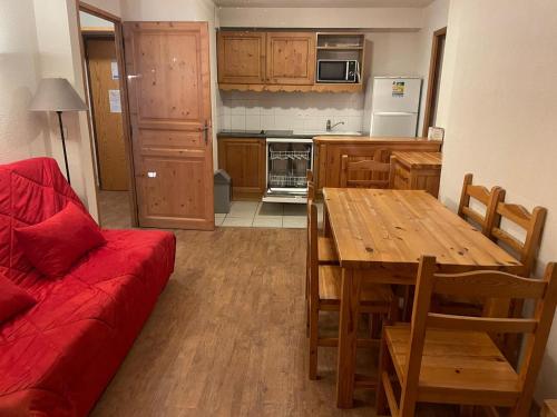 une cuisine avec une table en bois et un canapé rouge dans l'établissement Appartement 6 personnes Grand Panorama, à Saint-Gervais-les-Bains