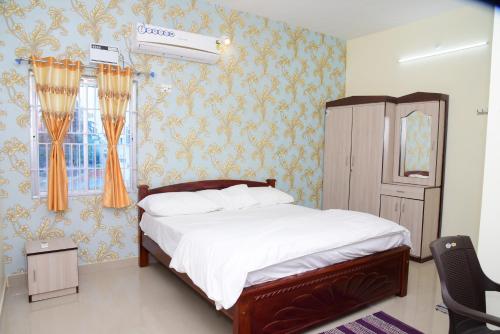 Schlafzimmer mit einem Bett und einem Fenster in der Unterkunft Maria Homez in Devakottai