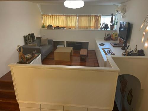 a small living room with a couch and a kitchen at Sigang Vacation Homestay in Xigang