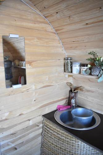 a bathroom with a sink and a wooden wall at Usmas zaķīšu pirtiņa - Bunny house in Usma