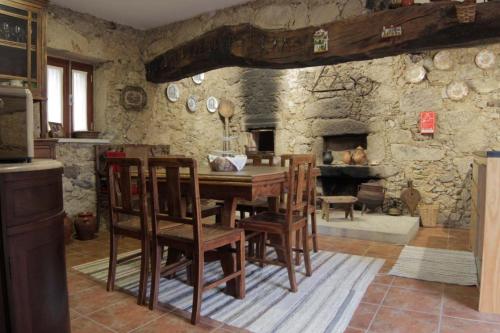 a dining room with a table and a stone wall at Casa Ventura in César