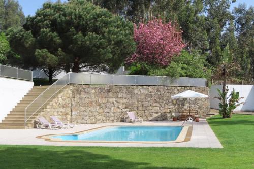 a swimming pool in a yard next to a stone wall at Casa Ventura in César