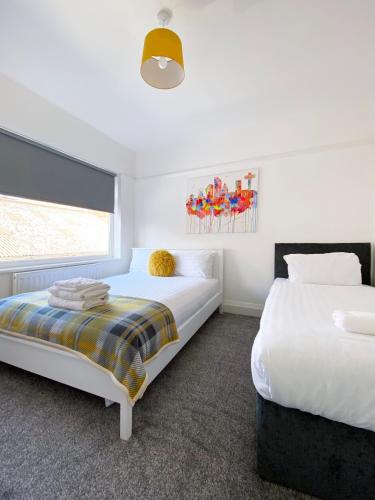 a bedroom with two beds and a window at The Baltic Townhouses by Serviced Living Liverpool in Liverpool