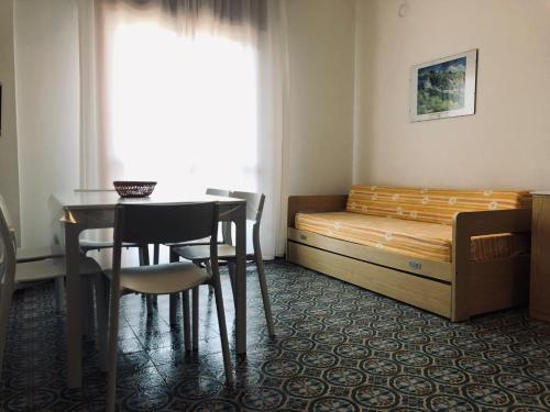 a bedroom with a bed and a table and chairs at Appartamento Renata in Grado