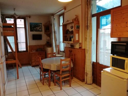 une cuisine avec une table et des chaises dans une pièce dans l'établissement Studio chaleureux à Saint-Gervais-les-Bains, 23m², vue montagne, à Saint-Gervais-les-Bains