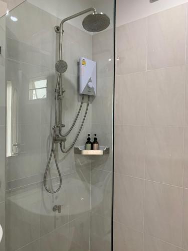 a shower with a shower head in a bathroom at Siri Ville Hotel in Si Sa Ket