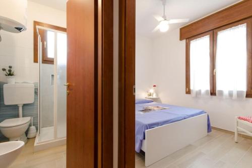 y baño con cama, aseo y lavamanos. en Villa Giuri, en Lido di Pomposa