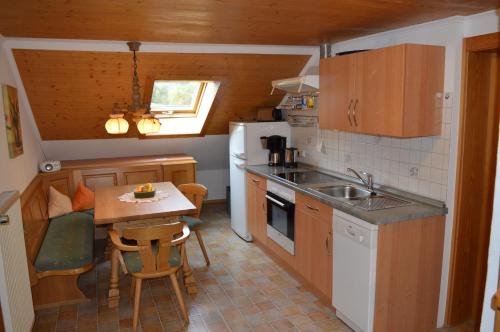 een keuken met een wastafel en een tafel met stoelen bij Ferienwohnungen Kilianmühle in Berchtesgaden