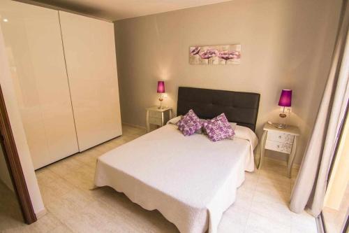 コラレホにあるAnju Villas Casa Juanのベッドルーム1室(紫色の枕が付いたベッド1台付)