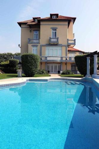a large blue swimming pool in front of a house at Casa da Granja - Boutique in Vila Nova de Gaia
