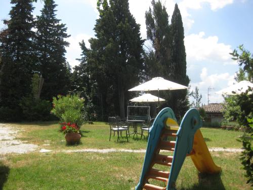 a playground with a table and chairs and an umbrella at Country House-B&B-Appartamenti Ai Cipressi in Urbino