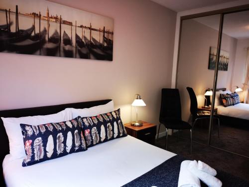 um quarto de hotel com uma cama e uma cadeira em Mycosy 605 em Paisley